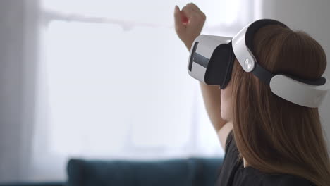 Frau-Verwendet-Modernes-HMD-Display-Und-Berührt-Virtuelle-Realität-Mit-Der-Hand-Porträt-Einer-Benutzerin-Mit-Gerät-Auf-Dem-Kopf-Moderne-VR-Technologie